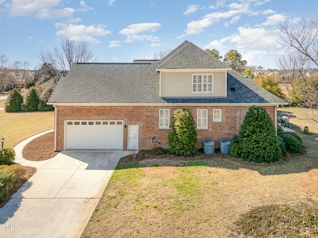 traditional-style house with a garage, a front yard, concrete driveway, and brick siding