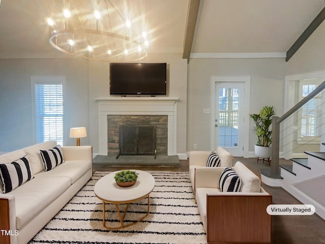 living area with beam ceiling, plenty of natural light, a stone fireplace, and stairs