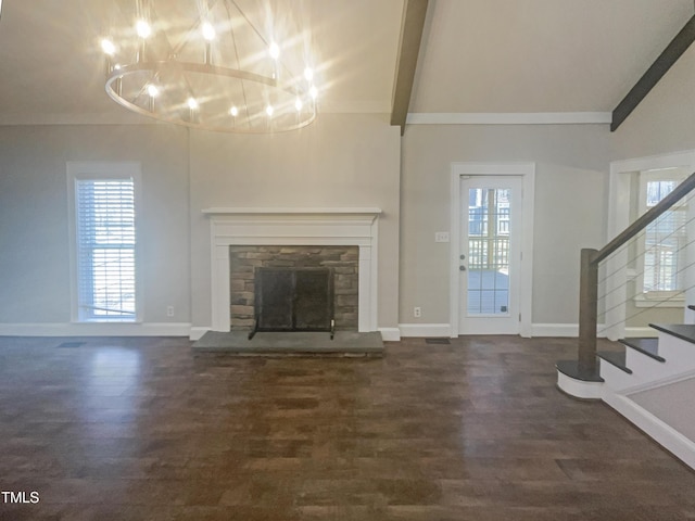 unfurnished living room with plenty of natural light, dark wood-style flooring, stairway, and a fireplace