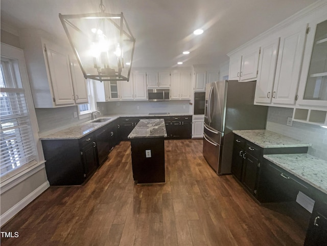 kitchen featuring stainless steel appliances, dark cabinetry, white cabinetry, and a center island