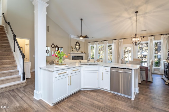 kitchen with dark wood-type flooring, open floor plan, dishwasher, and decorative columns