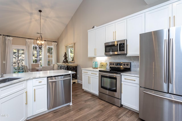 kitchen featuring lofted ceiling, appliances with stainless steel finishes, white cabinetry, and tasteful backsplash