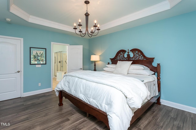 bedroom featuring a notable chandelier, a tray ceiling, and wood finished floors