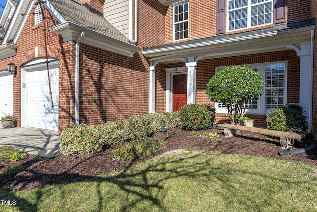 view of exterior entry featuring brick siding and an attached garage