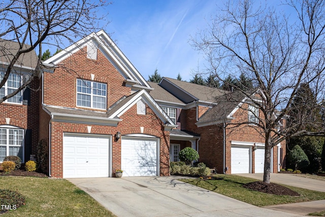 traditional-style house with a garage, roof with shingles, concrete driveway, and brick siding