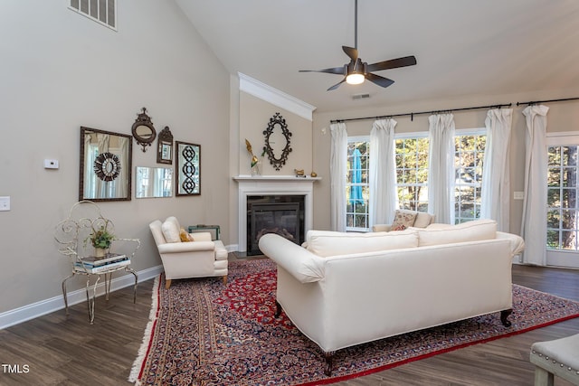 living room with baseboards, visible vents, dark wood-style flooring, and a glass covered fireplace