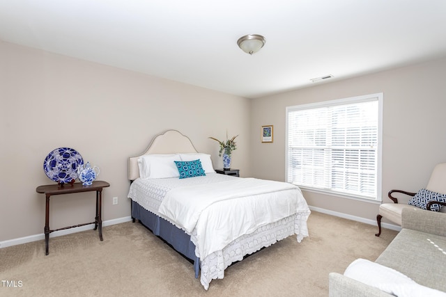 bedroom with light carpet, visible vents, and baseboards