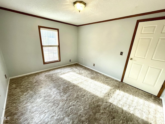 empty room featuring a textured ceiling, baseboards, carpet flooring, and crown molding