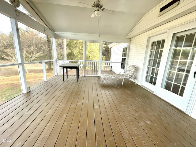 unfurnished sunroom with a ceiling fan and vaulted ceiling