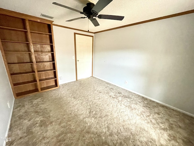 unfurnished bedroom with a textured ceiling, carpet floors, visible vents, baseboards, and crown molding