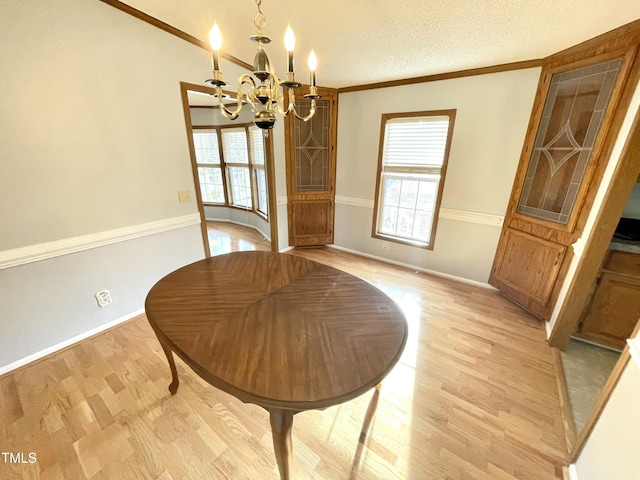 dining area with a chandelier, ornamental molding, a textured ceiling, and light wood finished floors