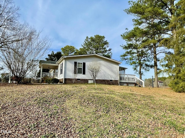 view of side of property with a yard and crawl space