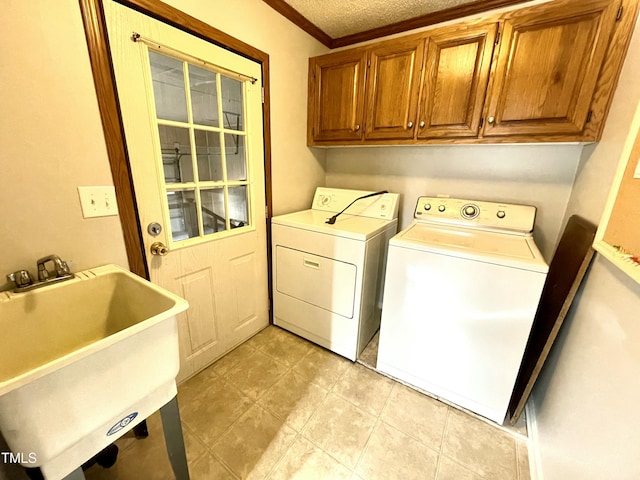 laundry room with cabinet space, ornamental molding, a textured ceiling, separate washer and dryer, and a sink