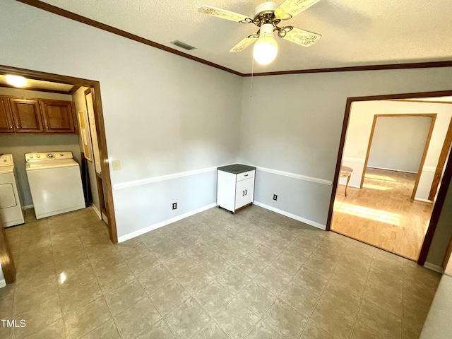 spare room featuring visible vents, ornamental molding, a ceiling fan, a textured ceiling, and washer and dryer