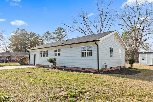 view of front of home featuring crawl space, an outdoor structure, and a front lawn