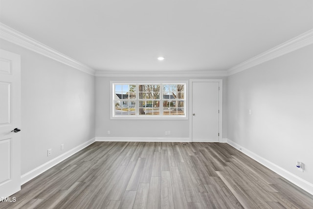 unfurnished room featuring baseboards, wood finished floors, and ornamental molding