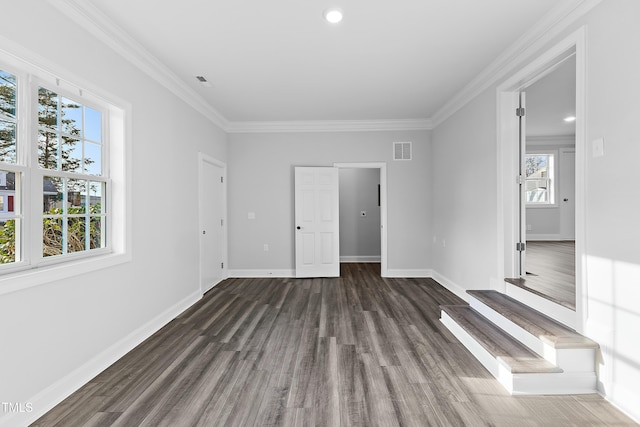 unfurnished bedroom with dark wood finished floors, visible vents, baseboards, and ornamental molding