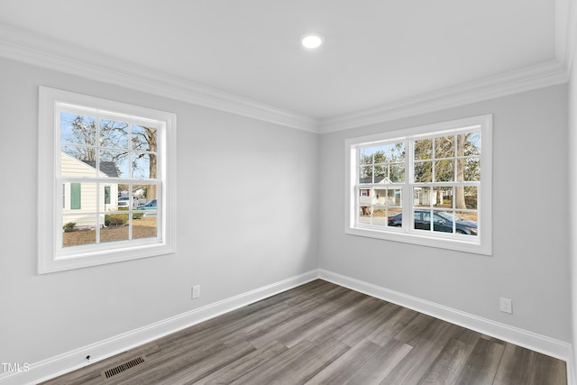 empty room featuring dark wood finished floors, crown molding, plenty of natural light, and baseboards