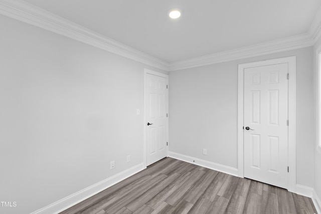 unfurnished room featuring wood finished floors, baseboards, and ornamental molding