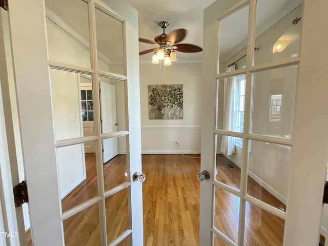 doorway featuring ornamental molding, wood finished floors, french doors, baseboards, and ceiling fan