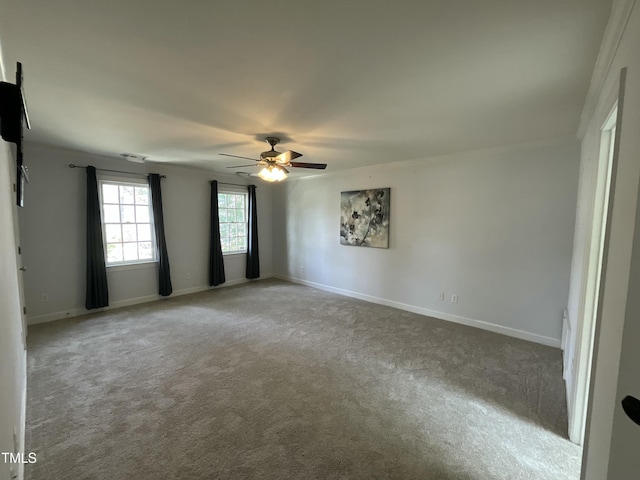 spare room with baseboards, carpet floors, and a ceiling fan