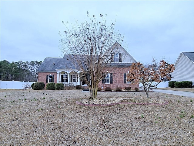 view of front of house with brick siding and fence