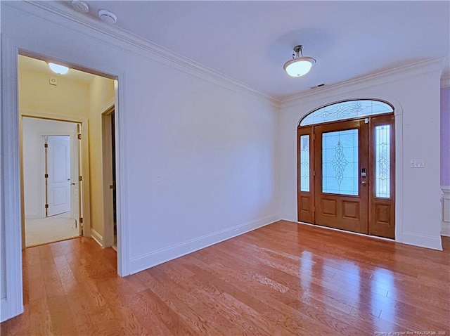 foyer entrance featuring visible vents, ornamental molding, light wood-style flooring, and baseboards