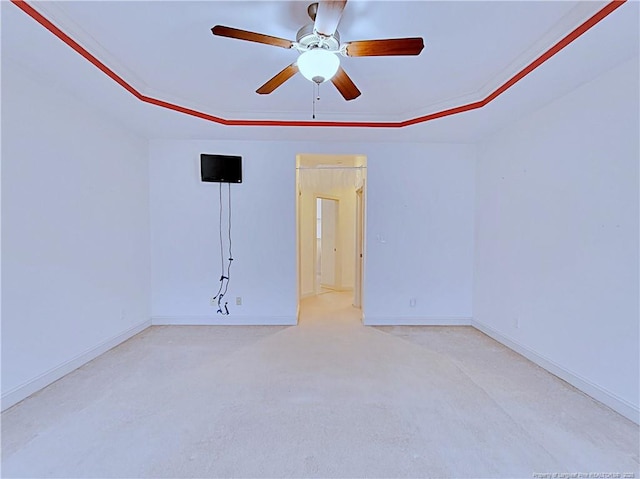 spare room featuring baseboards, a tray ceiling, and ceiling fan