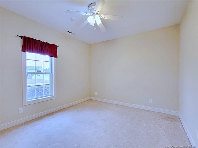 spare room featuring baseboards, light carpet, visible vents, and a ceiling fan