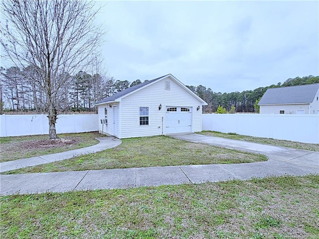 garage featuring driveway and fence