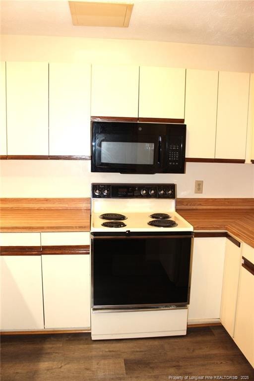 kitchen with white cabinetry, black microwave, dark wood-type flooring, and electric range oven