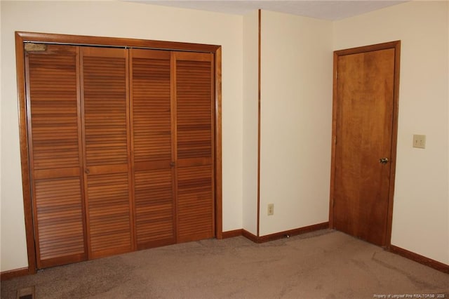 unfurnished bedroom with light carpet, a closet, visible vents, and baseboards