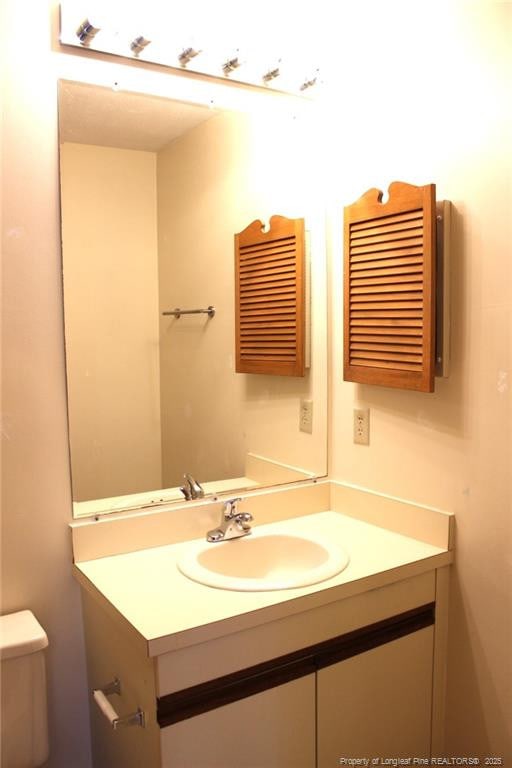 half bathroom featuring toilet and vanity