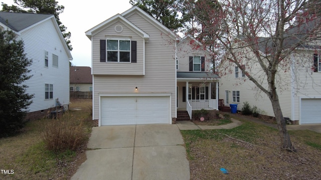 traditional home featuring a porch, a garage, and driveway