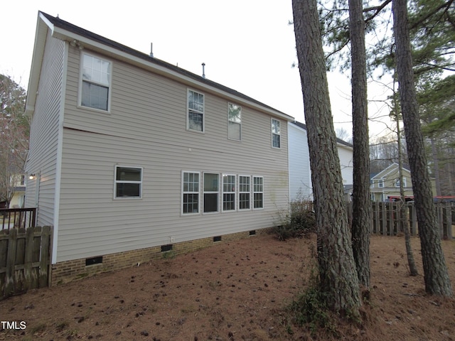 rear view of property with crawl space and fence