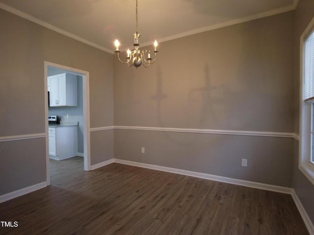 unfurnished dining area with dark wood finished floors, crown molding, baseboards, and a chandelier