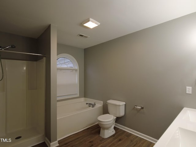 bathroom with visible vents, walk in shower, a garden tub, and wood finished floors