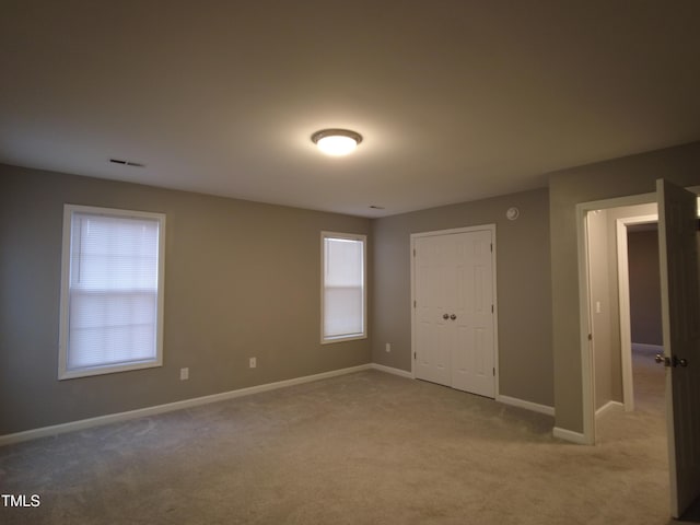 spare room with visible vents, baseboards, and carpet