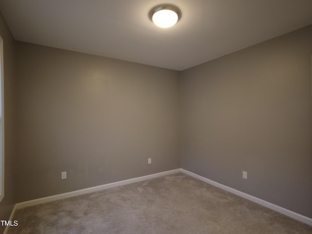 carpeted spare room with baseboards