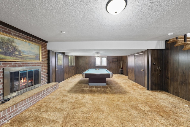 rec room featuring carpet floors, wooden walls, pool table, and a fireplace