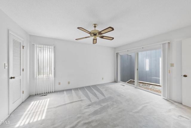 unfurnished bedroom featuring visible vents, a ceiling fan, access to outside, a textured ceiling, and carpet floors