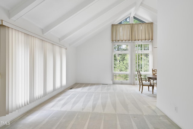 interior space featuring light colored carpet and vaulted ceiling with beams