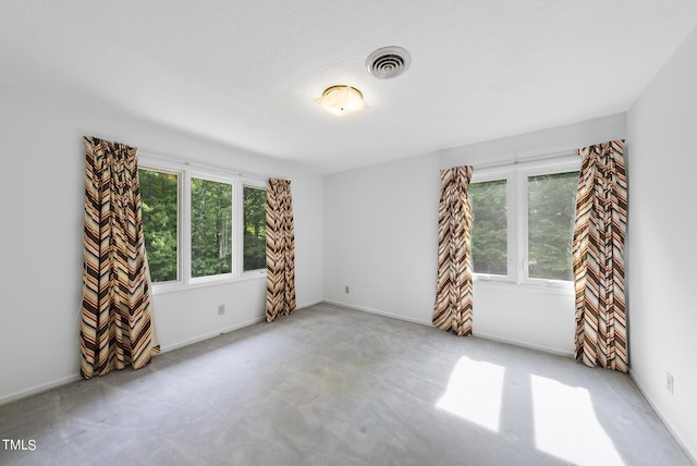 carpeted empty room featuring baseboards and visible vents