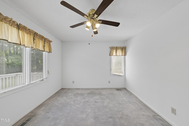 spare room featuring visible vents, a textured ceiling, baseboards, light colored carpet, and ceiling fan