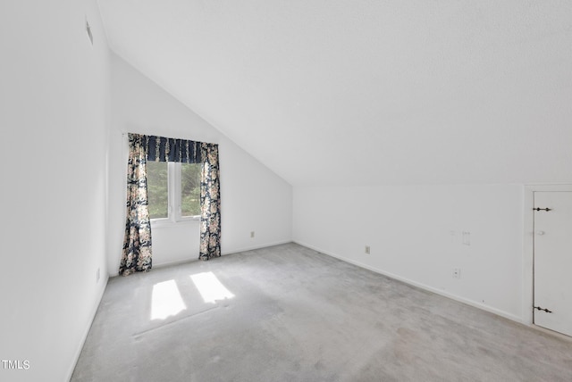 bonus room with vaulted ceiling and carpet