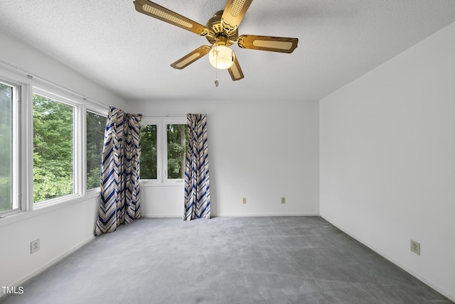 empty room featuring baseboards, carpet floors, a textured ceiling, and a ceiling fan