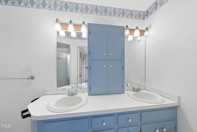 bathroom featuring double vanity, a shower stall, and a sink