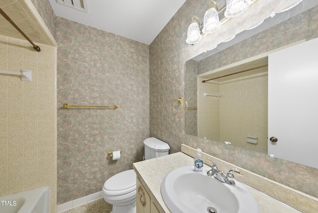 full bathroom featuring wallpapered walls, baseboards, toilet, vanity, and a textured ceiling