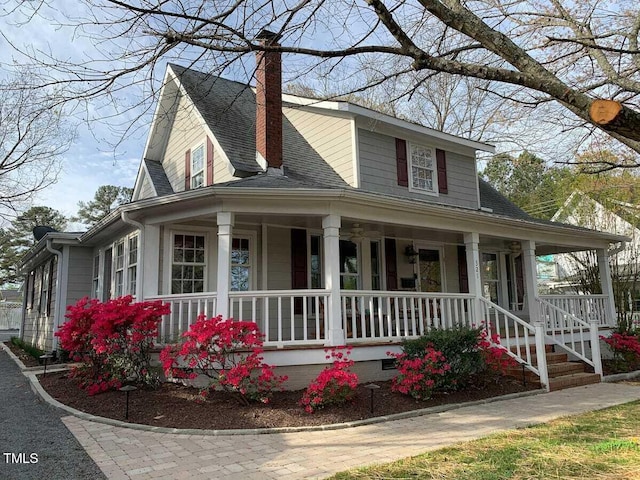 country-style home with crawl space, roof with shingles, covered porch, and a chimney