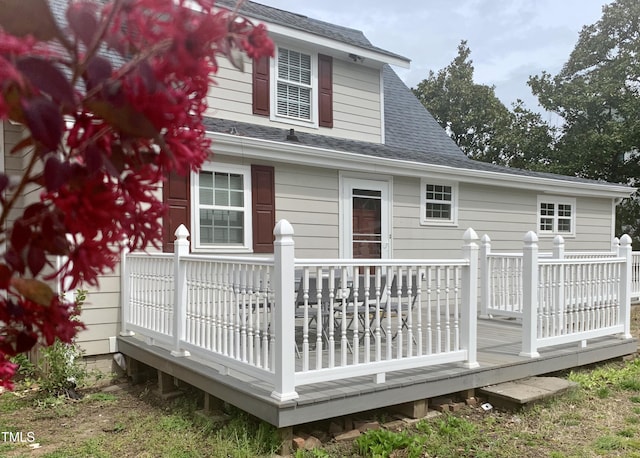 rear view of property with roof with shingles and a wooden deck